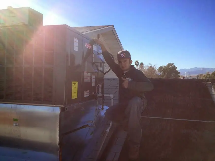 HVAC technician performing Heat Pump Repair on a rooftop unit in Skowhegan